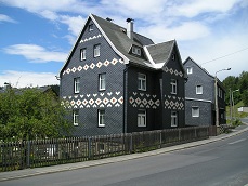 Geschiefertes Haus mit grauen und weißen Schieferplatten